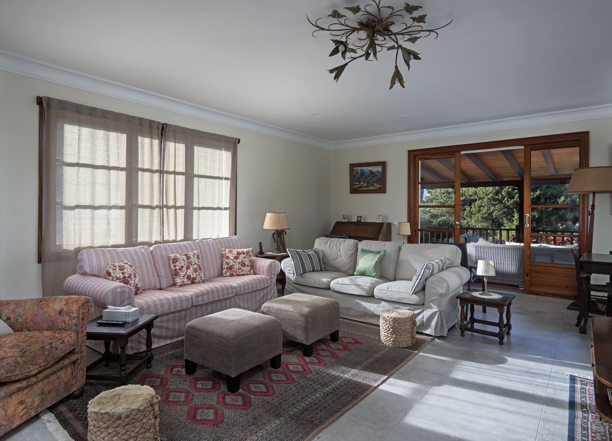 A living room with two sofas, a coffee table, a rug, and a chandelier.