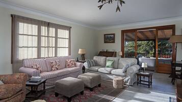 A living room with two sofas, a coffee table, a rug, and a chandelier.