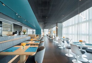 A modern restaurant with a long counter, seating area, and large windows. - Pagoda Hotel, Baoan,qianhai, Shenzhen (Shenzhen)