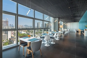 A modern dining area with large windows, contemporary chairs, and a city view. - Pagoda Hotel, Baoan,qianhai, Shenzhen (Shenzhen)