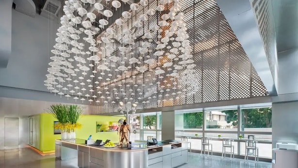 A modern hotel lobby with a central reception desk, large windows, and a ceiling adorned with hanging white umbrellas. - Pagoda Hotel, Baoan,qianhai, Shenzhen (Shenzhen)