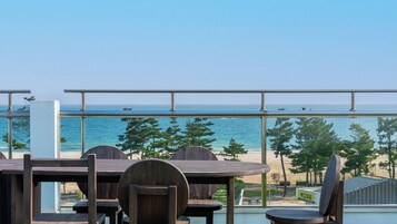 Una terraza con vistas al mar, con mesas y sillas de madera.