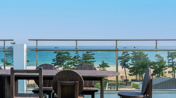 Una terraza con vistas al mar, con mesas y sillas de madera.