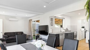 A modern apartment with a dining area, kitchen, living room, and a balcony. - Fantastic Family Lakehouse - Room for everyone (Mangakino)