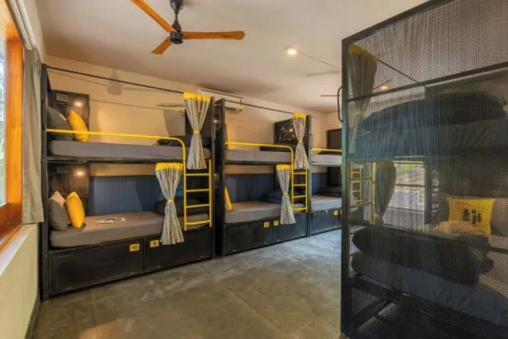 Ein kleines Zimmer mit Etagenbetten, Deckenventilator und Fenster mit Blick.