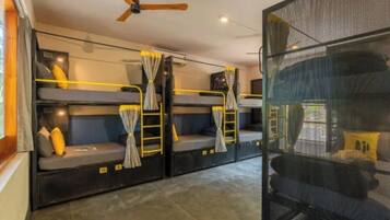 Ein kleines Zimmer mit Etagenbetten, Deckenventilator und Fenster mit Blick.