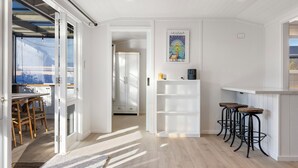 A bright kitchen with white cabinetry, a coffee machine, and a framed poster on the wall. - Luxury Hideaway at the Lake (Mangakino)