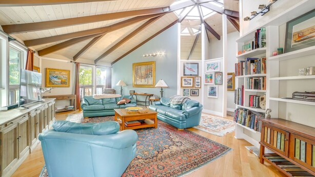 A spacious living room with a high ceiling, a large bookshelf, and a cozy seating area. - Redwood Retreat Near Beach & Trails (Aptos)