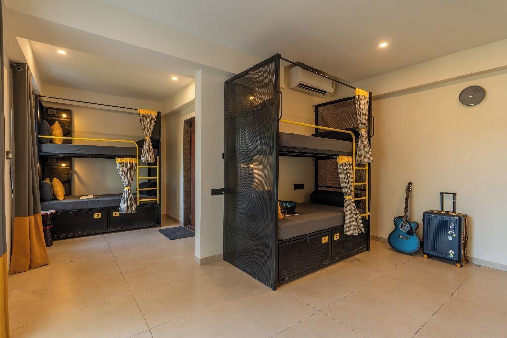 Ein Zimmer mit Etagenbetten, einer Gitarre und einem Koffer.