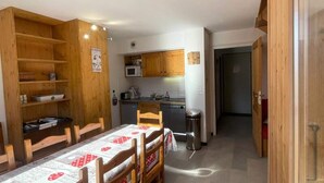 Cocina compacta con armarios de madera, un microondas y un lavamanos.