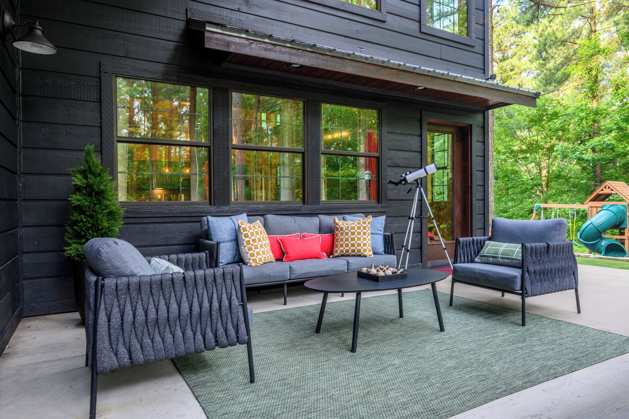 A modern outdoor seating area with a sofa, two armchairs, and a coffee table.