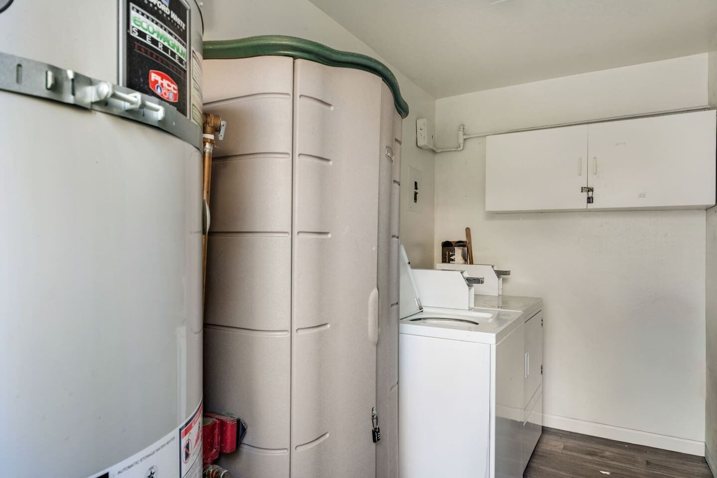 A compact laundry room with a washing machine, a dryer, and a water heater.