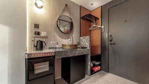 A modern kitchen with a built-in oven, a coffee maker, and a hanging mirror. - Kai Li Hotel (Wuhan)