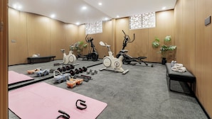 A gym with exercise equipment, mats, and benches. - Kai Li Hotel (Wuhan)
