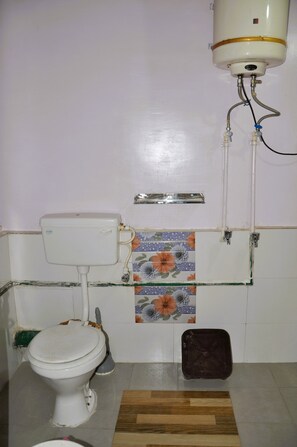 Pieni kylpyhuone, jossa on wc, suihku ja pesuallas.