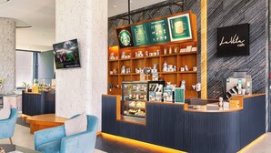 A modern cafe interior with a counter, seating area, and menu boards. - Studio in LaVita Condo in Rawai 7501 (Rawai)