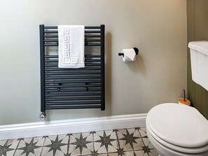 A bathroom with a black towel rack, toilet paper holder, and a toilet. - The Butterchurn - UK50805 (Cratfield, near Laxfield)