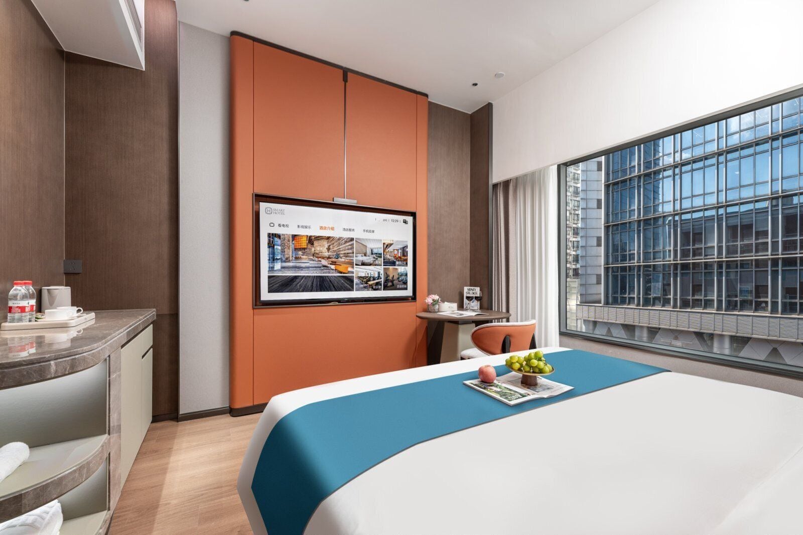 Una habitación de hotel moderna con una cama grande, un escritorio, un televisor en la pared y un ventanal con vistas a la ciudad.