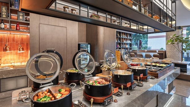 A buffet area with various food stations, including hot pots and a selection of dishes. - From.K Hotel (Guangzhou Tianhe Zhengjia Plaza Tiyuxi Road Metro Station Branch) (Guangzhou)
