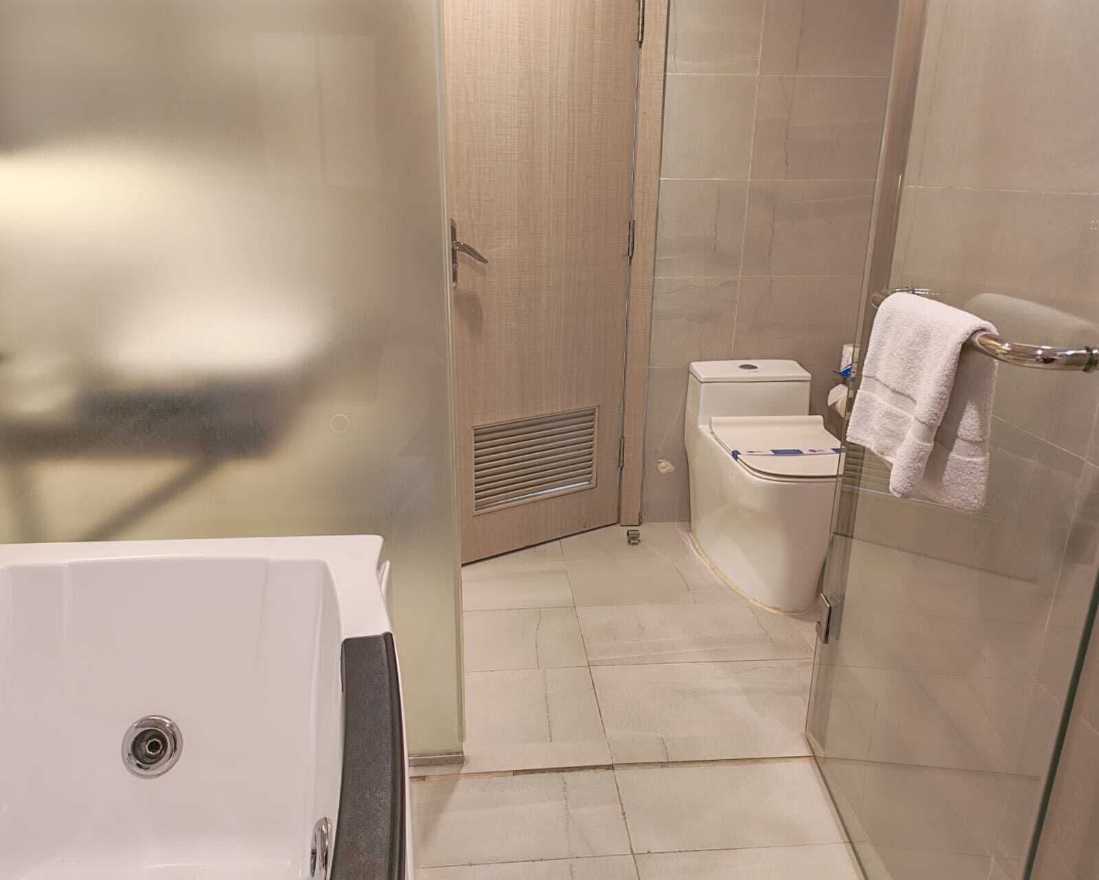 A bathroom with a glass shower enclosure, a white toilet, and a bathtub.