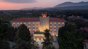 A hotel with a central courtyard, multiple floors, and a mountain backdrop.