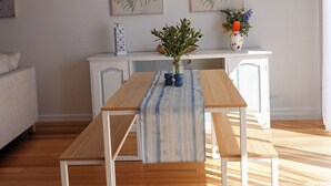 A dining area with a wooden table, benches, and a vase of flowers. - Casa Mar - Beachside Bliss.
Sun, sand and family fun All in one place. (Carrum)