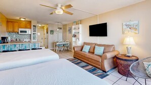A hotel room with a kitchenette, a sofa, a TV, and a dining area. - Beach Front Ocean Front Condo Top of the Gulf 516 (Panama City Beach)