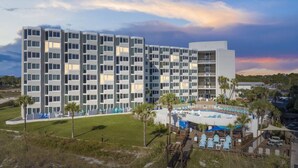 A multi-story hotel with a pool area, including lounge chairs and a deck. - Beach Front Ocean Front Condo Top of the Gulf 516 (Panama City Beach)