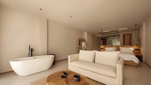 Une chambre d’hôtel moderne dotée d’une grande baignoire, d’un canapé et d’un lit avec une tête de lit en bois.