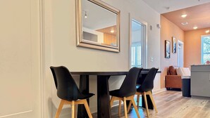 Un espace repas moderne avec une table en bois foncé et des chaises noires.