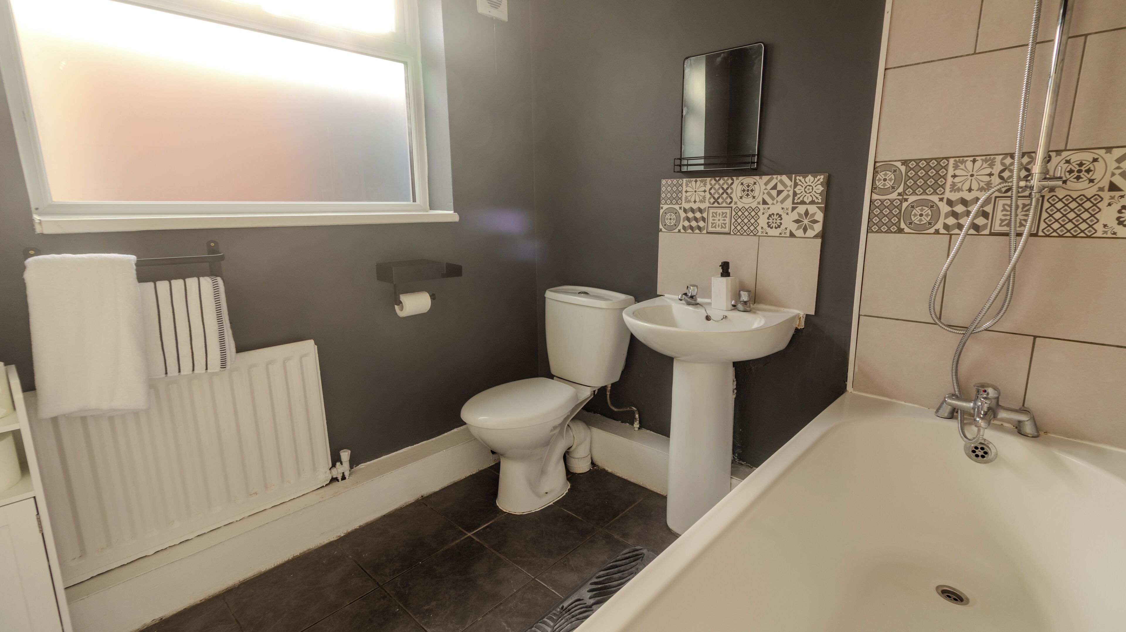 A bathroom with a toilet, sink, and bathtub.
