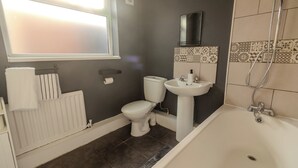 Ein Badezimmer mit Toilette, Waschbecken und Badewanne.