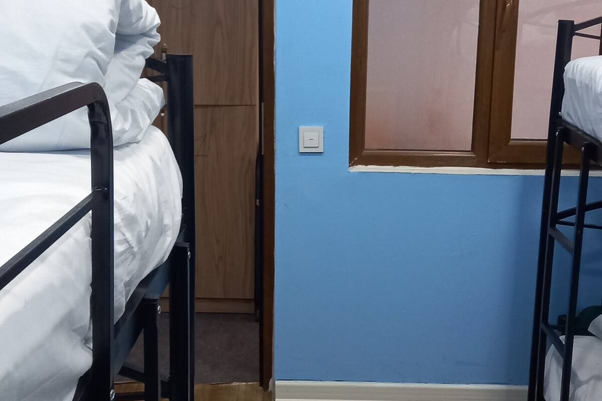 Quarto com beliches e guarda-roupa de madeira.