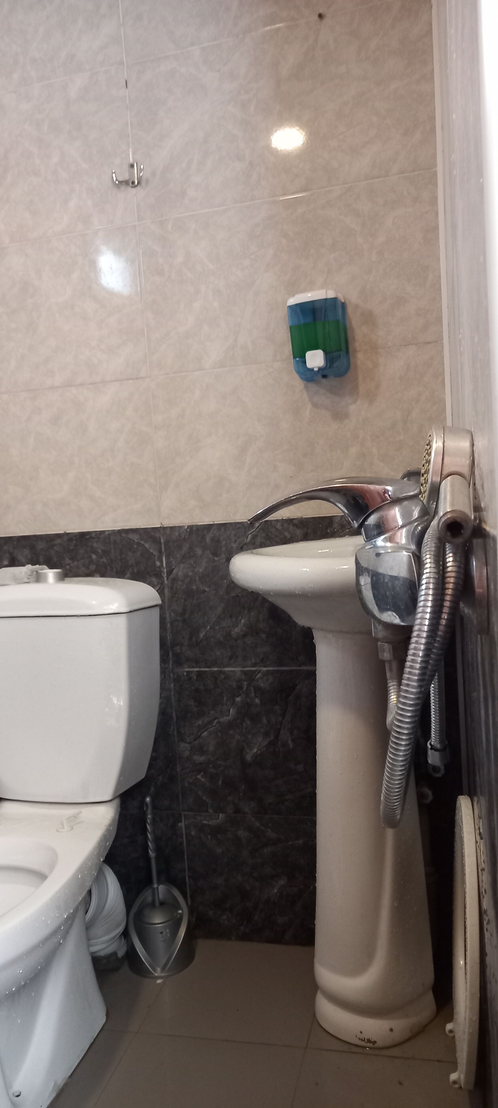 A bathroom with a toilet, a bidet, and a hand dryer.