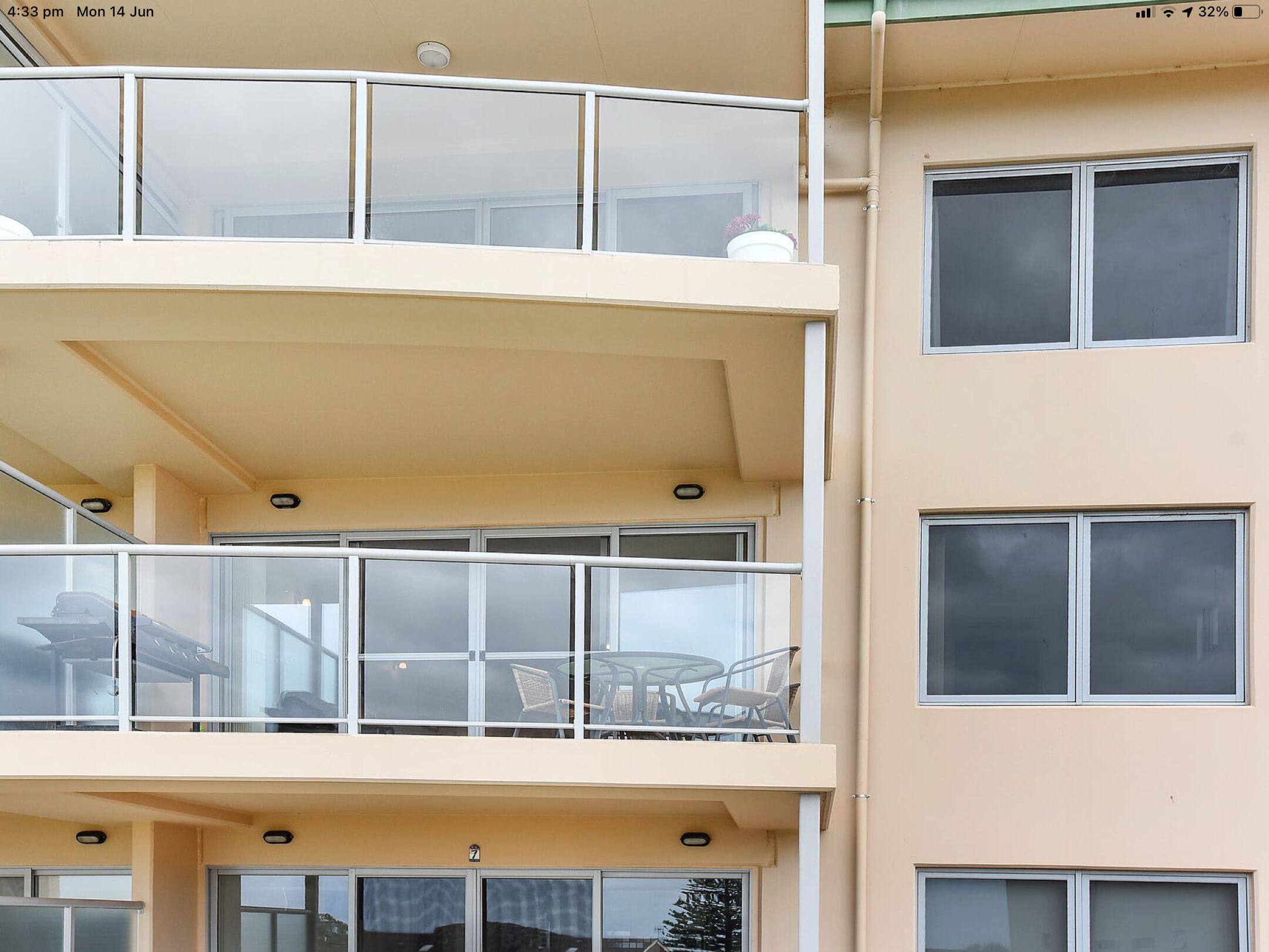 A multi-story building with balconies, large windows, and a flat facade.