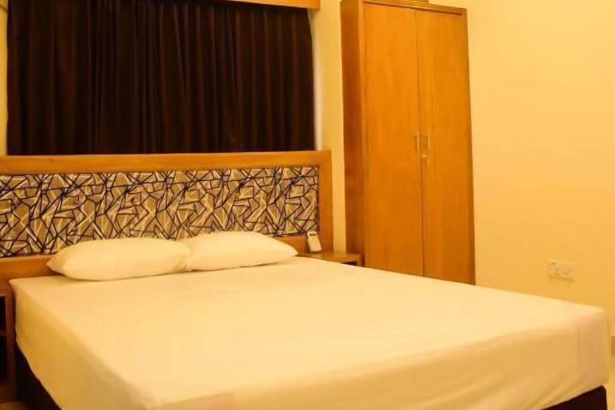 Un dormitorio con cama, armario y lámpara en el techo.