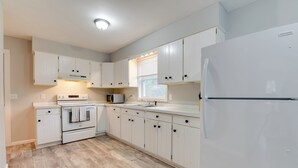 A kitchen with white cabinets, a built-in oven, a microwave, and a refrigerator. - Ski, Hike & Explore: Home 5 Mi to Dtwn Burlington! (Essex Junction)