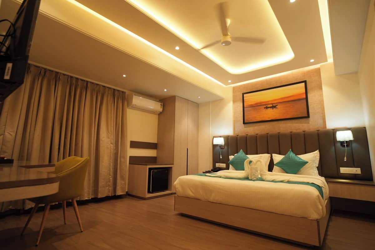 Una habitación de hotel moderna con una cama, lámparas de noche, un escritorio y una silla.