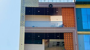 A multi-story building with a signboard advertising AC non-AC rooms. - Rukmani Palace (Khandwa)
