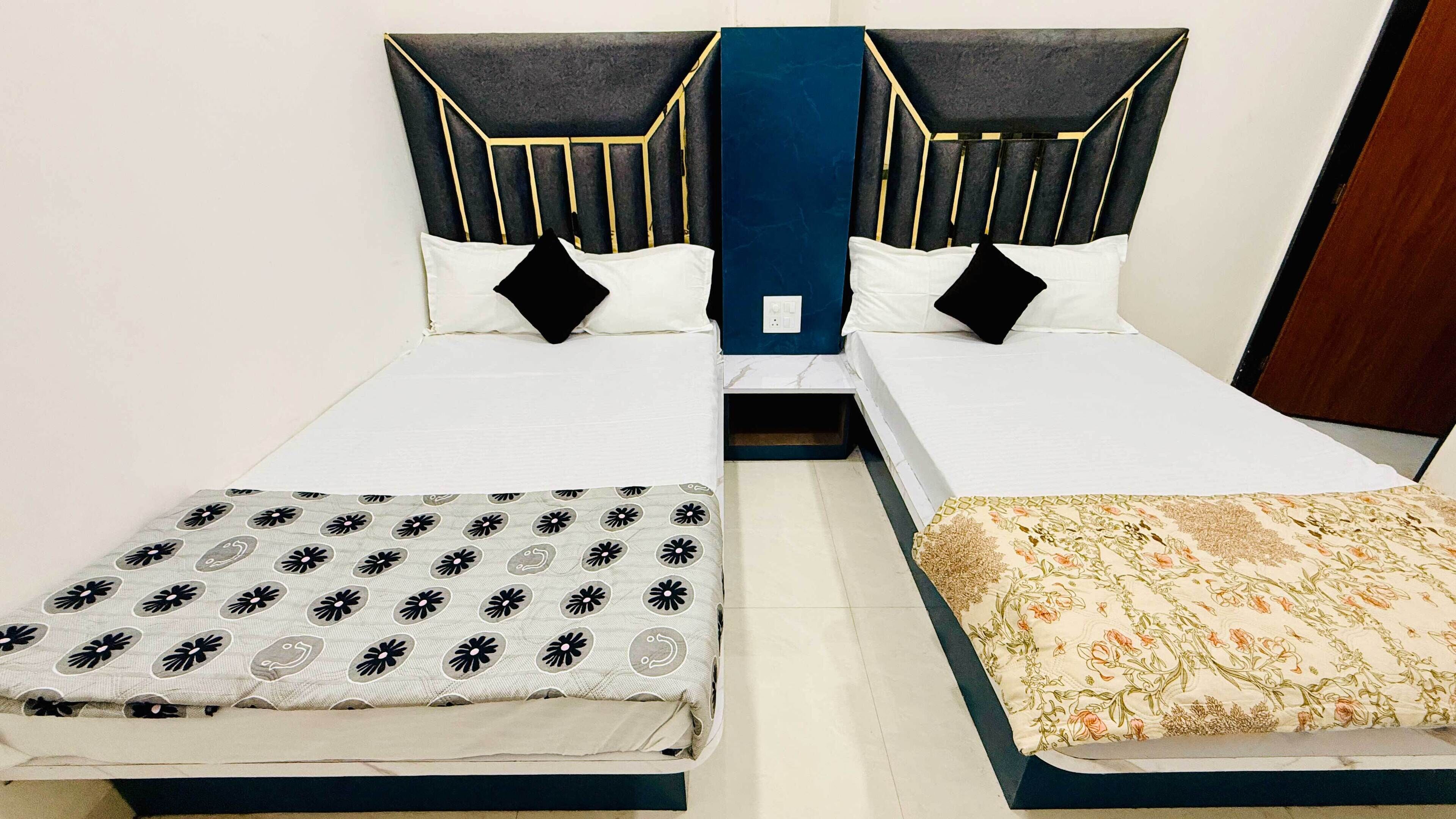 A double bed with a floral bedspread and a black and white patterned bedspread.