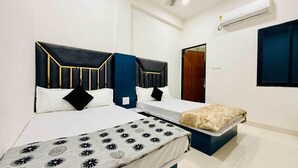 A hotel room with two beds, a large mirror, and a window. - Rukmani Palace (Khandwa)