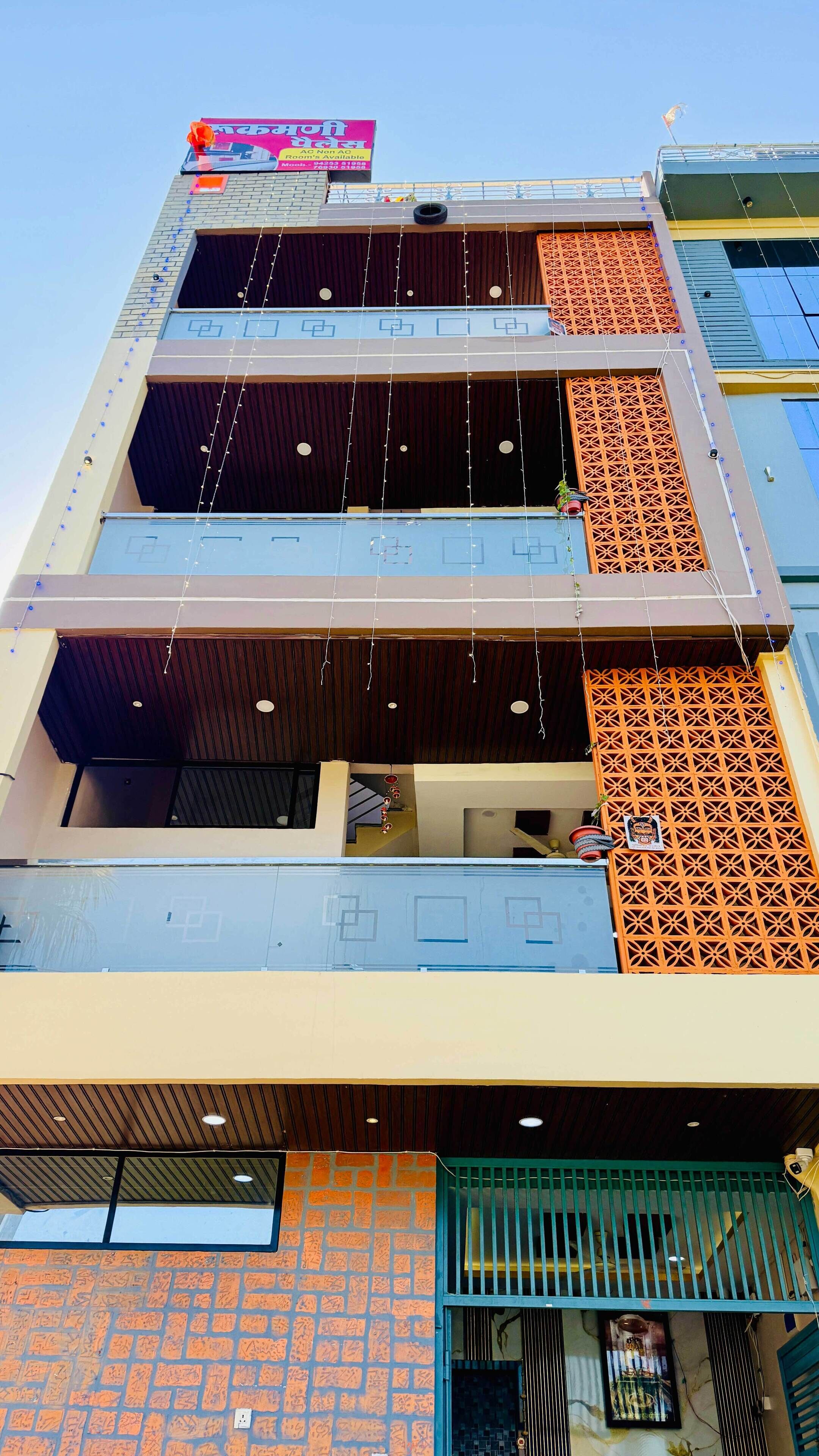 Un edificio de varios pisos con balcones, una escalera y un letrero que indica la disponibilidad de habitaciones.
