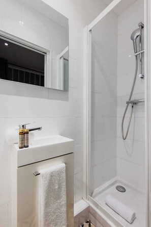 Chuveiro, toalhas de banho, shampoo 