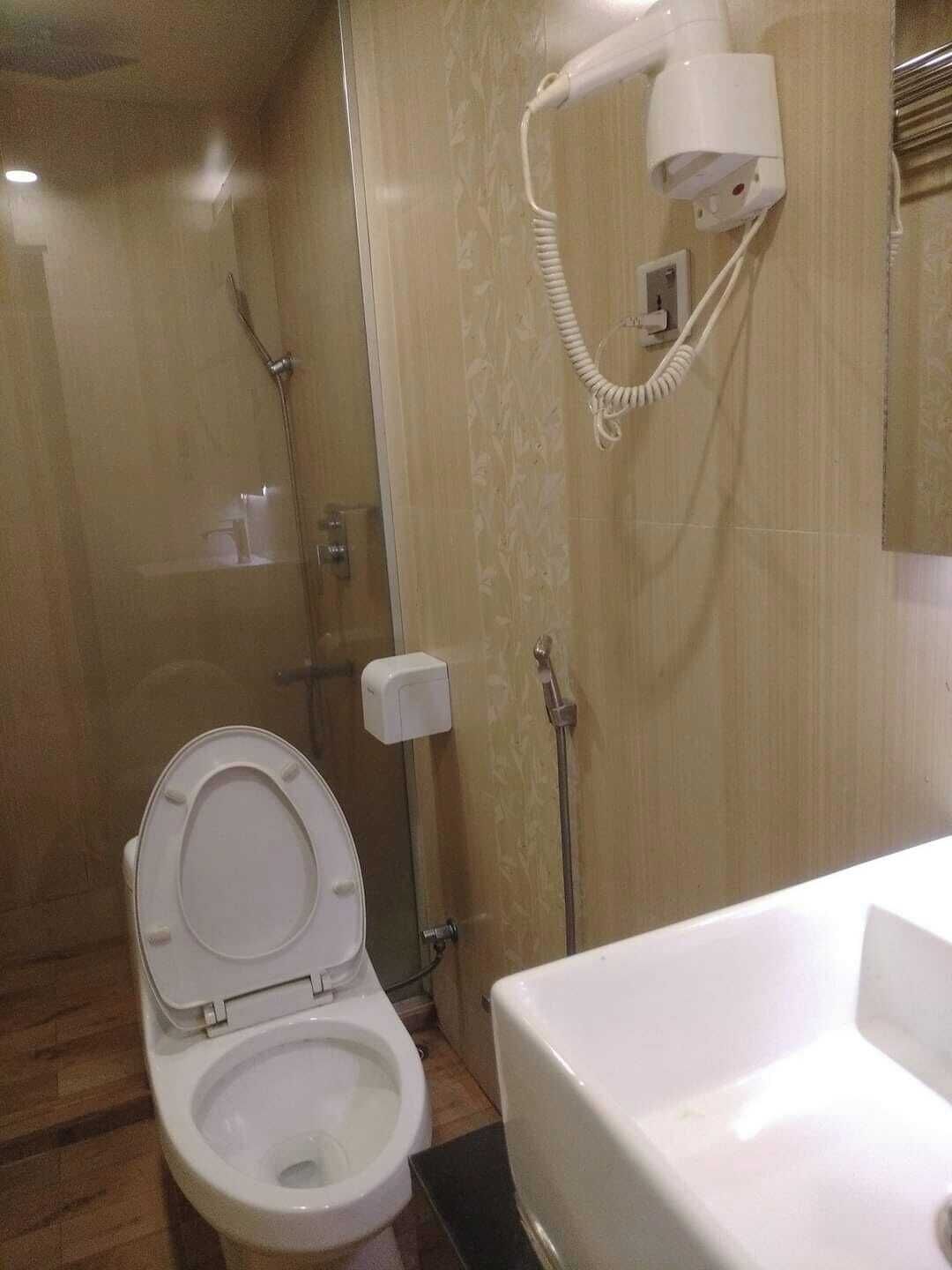 A bathroom with a toilet, a shower, and a sink.