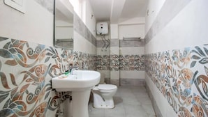 A small bathroom with a toilet, sink, and shower. - Rosewood Manali (Manali)