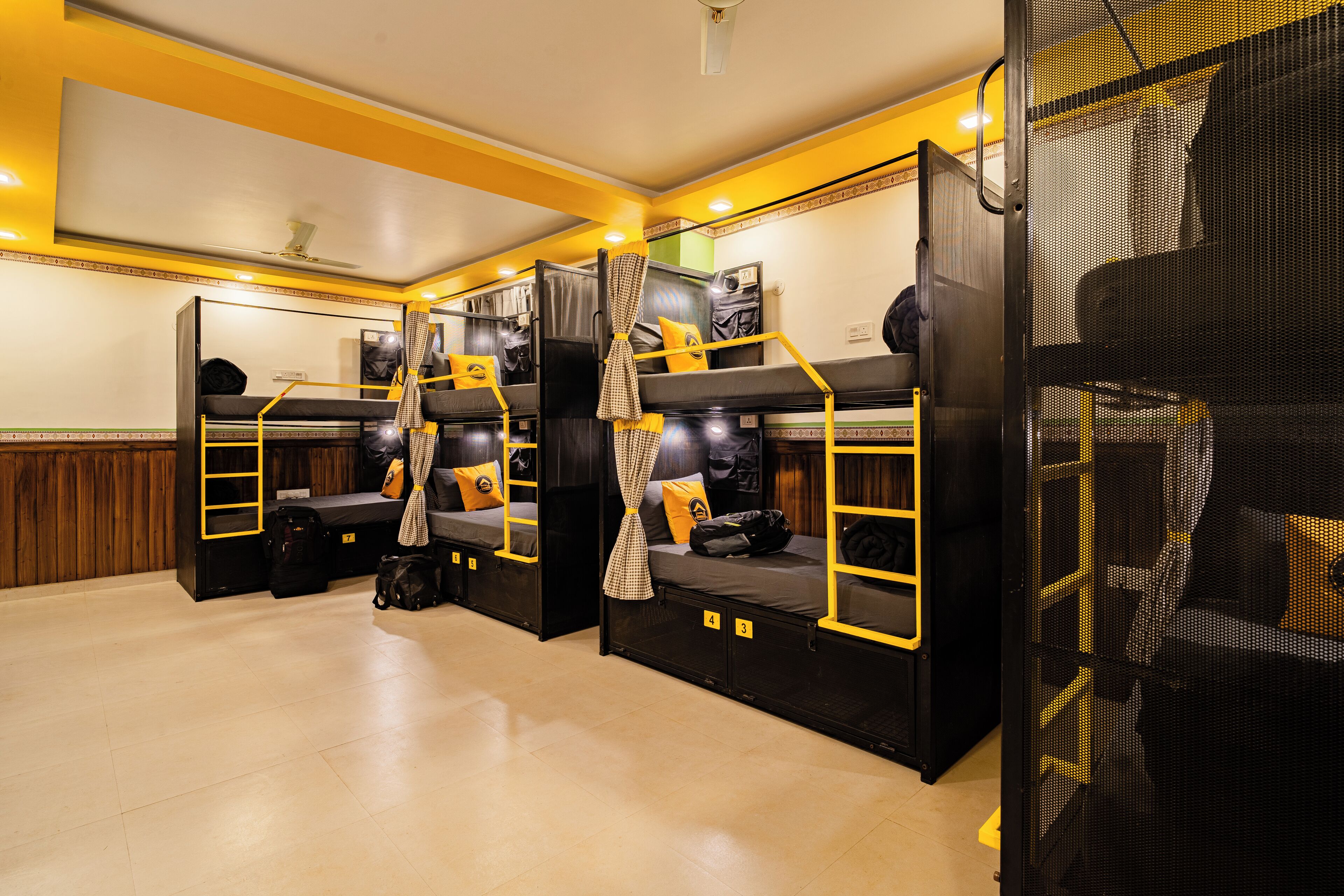 Un dormitorio con literas, ventilador de techo y ventana.