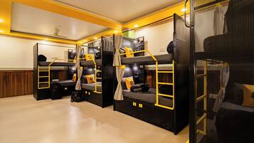 Un dormitorio con literas, ventilador de techo y ventana.