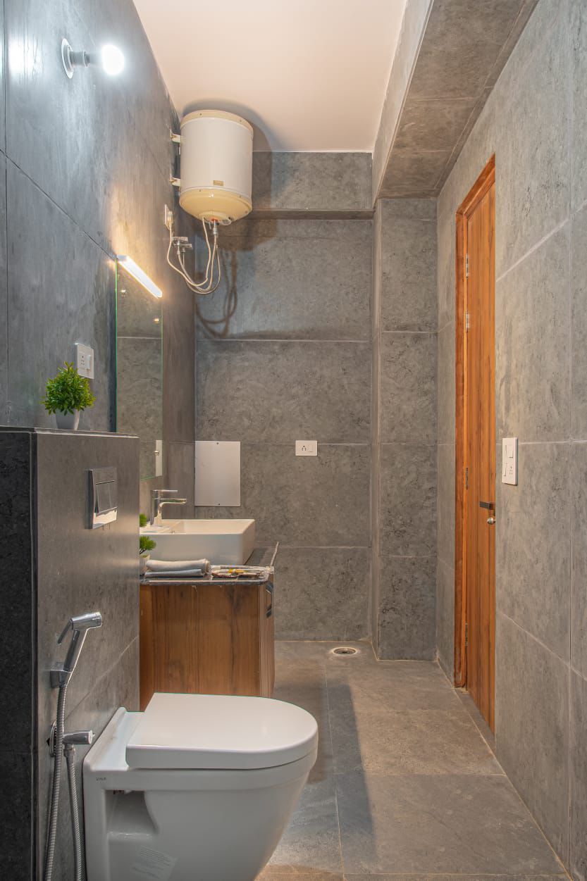 Une salle de bain moderne équipée de toilettes intégrées, d’un lavabo et d’un espace douche.