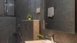 Un baño moderno con un lavamanos rectangular grande, un inodoro y una zona de ducha.