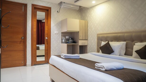 Una habitación de hotel con cama, armario, baño y kitchenette.